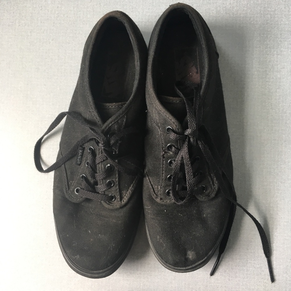 All black low top canvas Vans sneakers